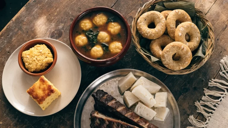 Mesa con platos típicos paraguayos: sopa paraguaya, chipa guasu, vori vori, chipa, costillas asadas y mandioca