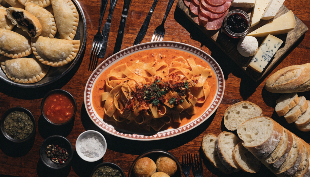 Mesa de restaurante servida con plato principal, guarnición y bebida. Imagen ilustrativa: no corresponde al local.