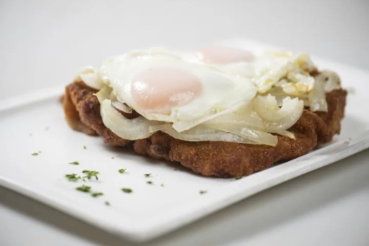 Milanesa de carne a caballo con huevos fritos y cebolla de Ña Eustaquia