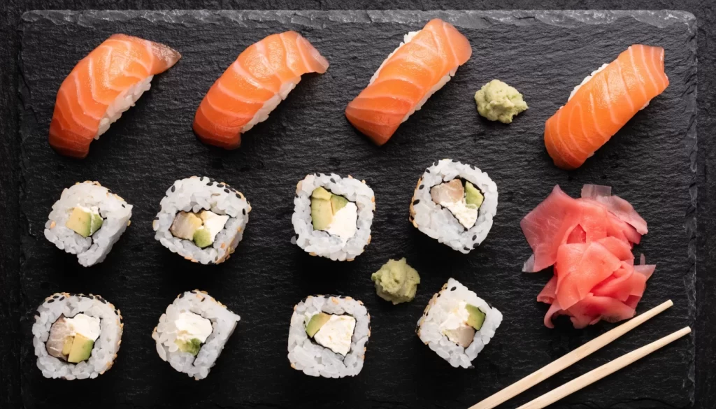 Tabla de sushi variado con nigiri de salmón, rolls, jengibre y wasabi. Imagen ilustrativa: no corresponde al local.