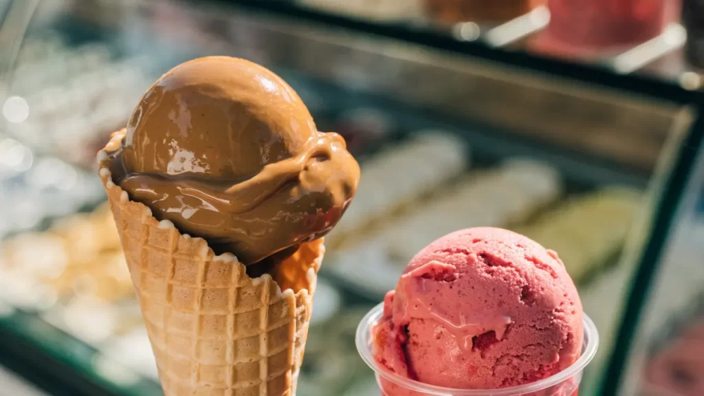 Helado artesanal de dulce de leche y frutilla en cucurucho y en vasito. Imagen ilustrativa: no corresponde al local.